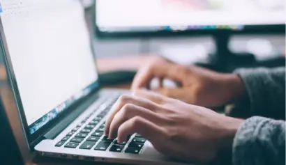Person typing on laptop, focus on hands and keyboard